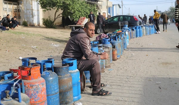 Palestinians line up for cooking gas during the second day of the truce between the resistance and the IOF in Rafah, Gaza Strip, Saturday, Nov. 25, 2023 (AP)