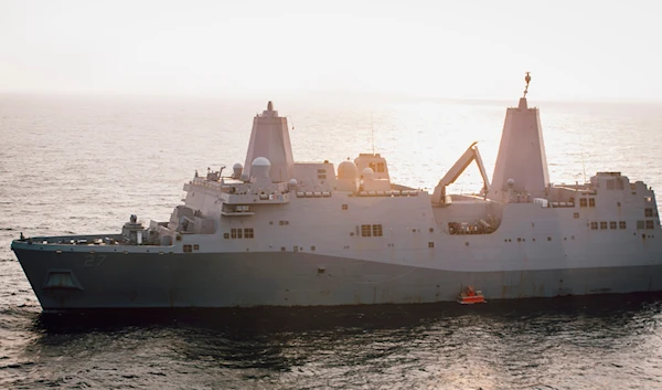 The USS Portland lowers a floating target into the water that it will later fire on with a laser weapon system, in the Gulf of Aden, December 14, 2021 (AP)