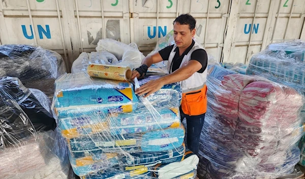 United Nations and Red Crescent workers prepare the aid for distribution to Palestinians at UNRWA warehouse in Deir Al-Balah, Gaza Strip, occupied Palestine, on Monday, Oct. 23, 2023. (AP)