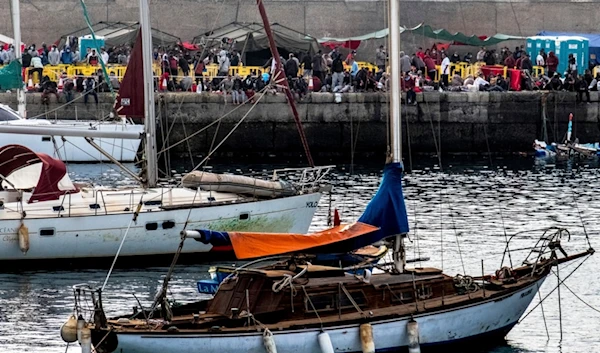 Migrants stand at the Arguineguin port in Gran Canaria island, Spain, after being rescued in the Atlantic Ocean by emergency workers on Thursday, Oct. 12, 2020 (AP)