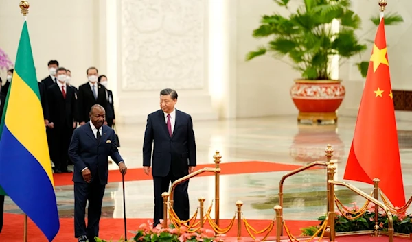 Gabonese President Ali Bongo Ondimba, left, and Chinese President Xi Jinping inspect an honor guard during a welcome ceremony at the Great Hall of the People in Beijing, Wednesday, April 19, 2023 (AP)