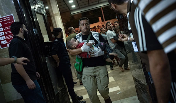 A wounded Palestinian child is carried into the Nasser Medical Complex, following Israeli airstrikes on the town of Khan Younis, southern Gaza Strip, Friday, Oct. 27, 2023(AP)