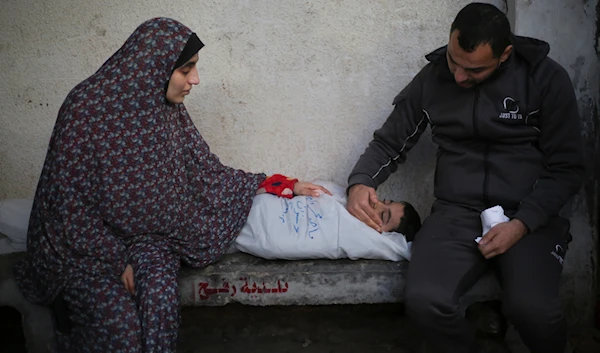 Palestinians mourn a child killed in the Israeli bombardment of the Gaza Strip at a hospital morgue in Rafah, Monday, Feb. 12, 2024. (AP)