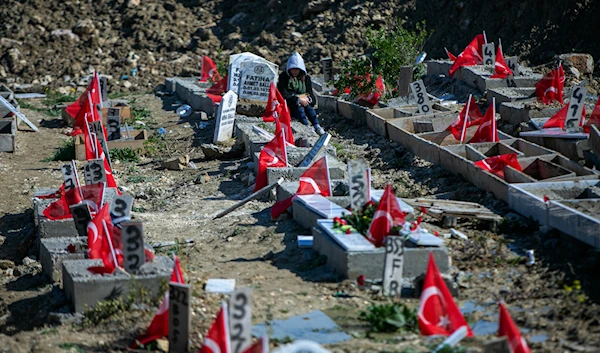 People visit graves in a cemetery where some of the victims of the powerful Feb. 6, 2023 earthquake are buried in Antakya, southern Turkey, Tuesday, Feb. 6, 2024. (AP)