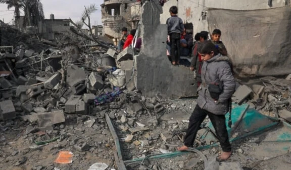 Palestinian children inspect the damage in the rubble of a residential destroyed by Israeli airstrikes on Rafah, in the southern Gaza Strip on February 12, 2024. (AFP)