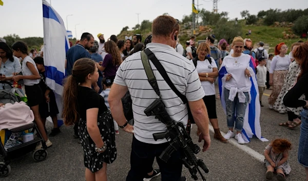 Armed Israeli settlers stand near the outpost of Eviatar in the occupied West Bank, Monday, April 10, 2023. (AP)