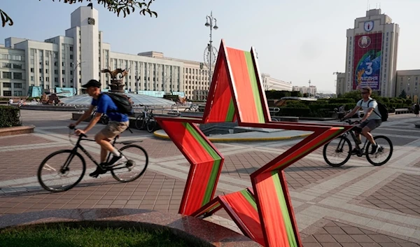 Men ride their bicycles in Independent Square during sunset in Minsk, Belarus, Wednesday, July 5, 2023. (AP Photo/Alexander Zemlianichenko)