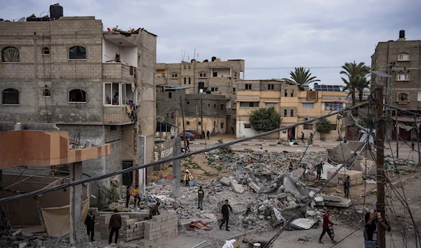 Palestinians inspect the rubble of the Hasouna family house, which was struck by an Israeli airstrike during an operation to rescue two hostages in Rafah, southern Gaza Strip, Tuesday, Feb. 13, 2024. (AP)