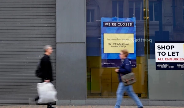 Pedestrians pass a closed retail unit on Oxford Street in London, Friday, Nov. 11, 2022 (AP)