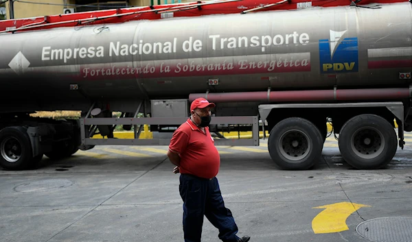 A worker wearing a face mask amid the coronavirus pandemic waits while a tanker truck supplies gasoline to a state oil company gas station in Caracas, Venezuela, Sunday, May 31, 2020(AP)