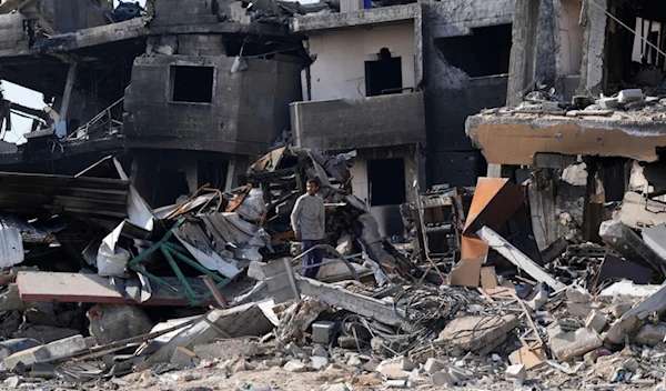 A Palestinian looks at th destruction by the Israeli bombardment in the Maghazi refugee camp, central Gaza Strip, Friday, Feb. 16, 2024 (AP Photo/Adel Hana)