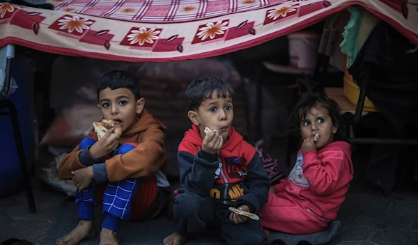 Palestinian children take shelter at a school run by the United Nations Relief and Works Agency for Palestine Refugees in the Near East (UNRWA), in Khan Yunis on November 15, 2023. (AP)