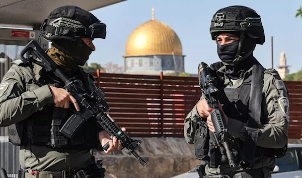 Israeli occupation forces block a street in al-Quds as Palestinians take part in Friday noon prayers on 24 November 2023, following an age restriction for worshippers wanting to access Al-Aqsa Mosque. (AFP)