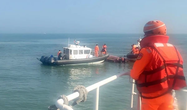 Handout photograph provided by Taiwan Coast Guard Administration, Taiwanese coast guards inspect a vessel that capsized during a chase off the coast of Kinmen archipelago in Taiwan, Feb. 14, 2024. (AP