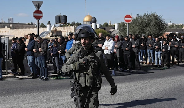 Palestinian Muslim worshipers who were prevented from entering the Al-Aqsa Mosque pray outside al-Quds's  Old City as Israeli occupation forces surround them Friday Dec. 22, 2023(AP)