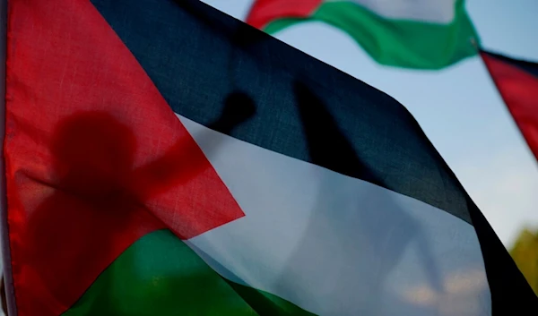 A Palestinian living in Cyprus waves a Palestinian flag at Elephtheria, Liberty, square in capital Nicosia, Sunday, May 16, 2021. (AP)