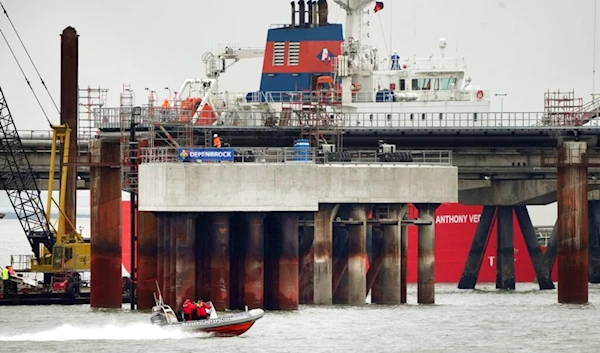 A police boat drives past the construction site of the 'Uniper' LNG (Liquefied Natural Gas) terminal in Wilhelmshaven, Germany, Tuesday, Nov. 15, 2022. (AP)