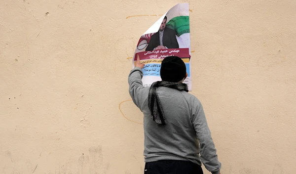 A man looks at an electoral poster of Hamid Abdolmaleki, a candidate for the March 1, parliamentary election, in Tehran, Iran, Thursday, Feb. 22, 2024. (AP)