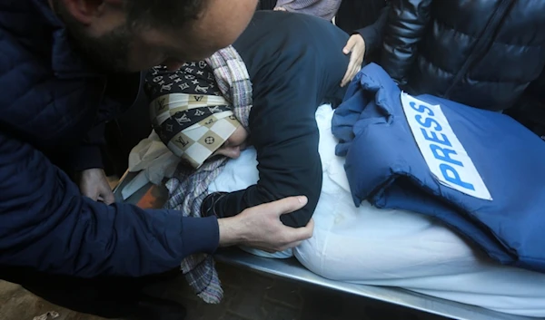 A relative mourns Palestinian journalist Akram Al-Shafi'i, killed in the Israeli bombardment of the Gaza Strip, in a morgue of the European Gaza Hospital in Rafah, Saturday, Jan. 6, 2024. (AP)