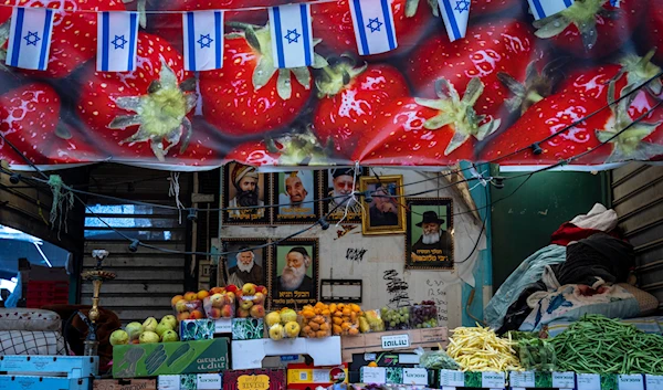 Israeli occupation flags above a fruit store at a market, in occupied Palestine Monday, April 17, 2023.(AP)