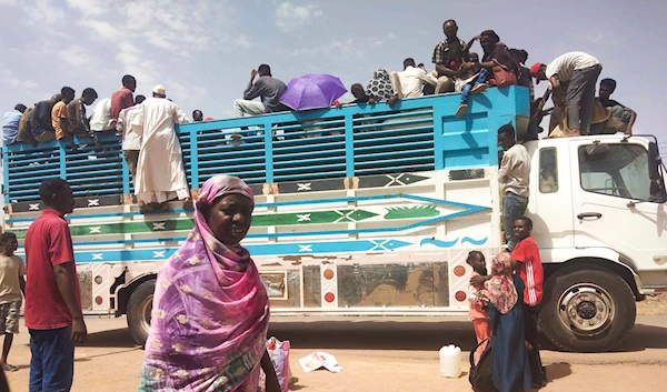 People board a truck as they leave Khartoum, Sudan, on June 19, 2023 (AP)