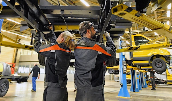 In this Oct. 9, 2018 file photo, workers assemble the new Deutsche Post StreetScooter Work XL electric delivery van at the Ford car plant in Cologne, Germany. (AP)