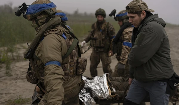 Ukrainian servicemen evacuate injured comrade at the frontline close to the Dnipro near Kherson, Oct. 14, 2023. (AP)