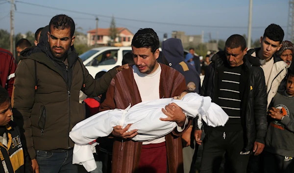 Palestinian Abdul Rahman Sharif holds the body of his four-year-old son Abdul Rahman Muamm, killed in the Israeli bombardment of Gaza, at his funeral in Khan Younis on Feb. 26, 2024. (AP)