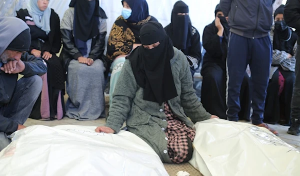 A Palestinian woman mourns relatives killed in the Israeli bombardment of the Gaza Strip in a morgue of the European Gaza Hospital in Khan Younis, Tuesday, Jan. 16, 2024. (AP)