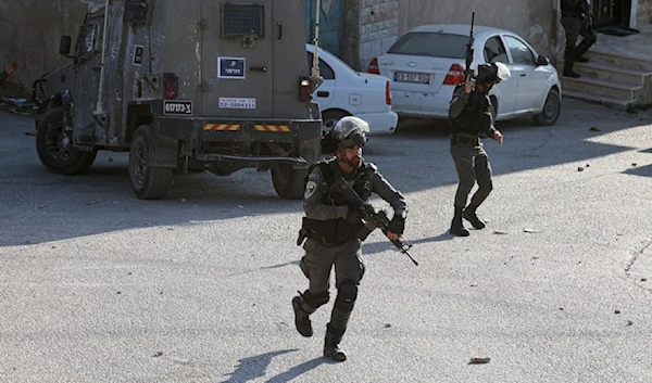 Israeli occupation soldiers advance during a raid on the West Bank town of Beita, August 21, 2023. (AFP)