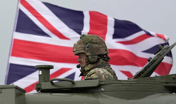 A British soldier sits in an AS90 as take part in a military exercise with Ukrainian soldiers at a military training camp in an undisclosed location in England, Friday, March 24, 2023 (AP)