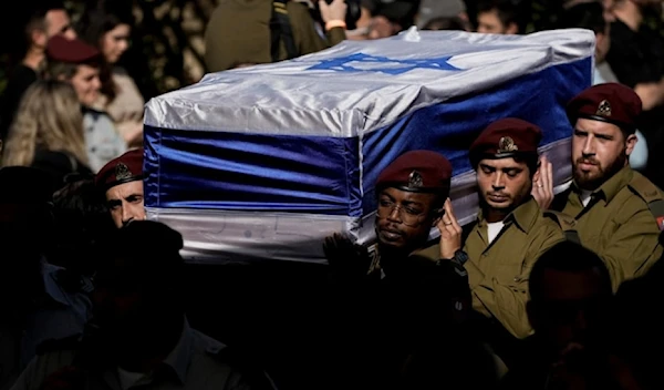 Israeli occupation forces carry the flag-draped casket of An Israeli occupation office who was killed in confrontations with the Palestinian Resistance in Gaza, December 8, 2023. (AP)