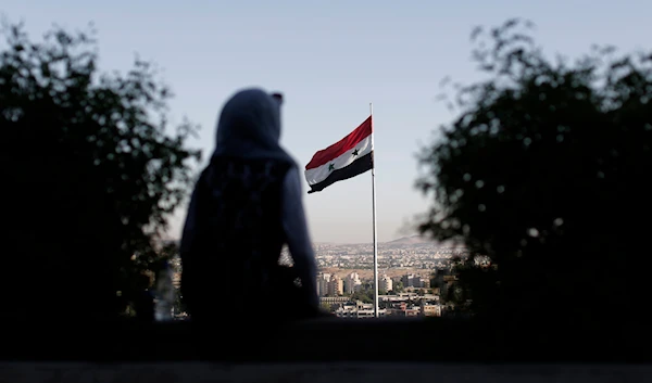 A young woman sits in a public garden overlooking the Syrian capital Damascus, Syria, July 24, 2019 (AP)