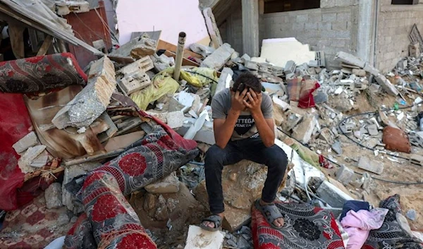 A Palestinian boy sits with his head in his hands after an Israeli airstrike killed his whole family. (AFP via Getty Images)