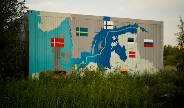 A painting showing the Nord Stream pipelines is displayed on a container near the Nord Stream 1 Baltic Sea pipeline in Lubmin, Germany, July 20, 2022. (AP)