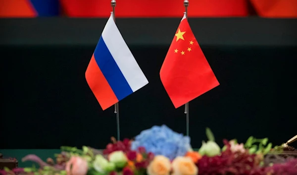 Russian, left, and Chinese flags sit on a table before a signing ceremony at the Great Hall of the People in Beijing, Friday, June 8, 2018. (AP)