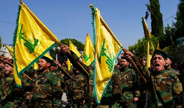 Hezbollah fighters rise their group's flag and shout slogans, during funeral processions in Majadel village, south Lebanon, Sunday, Oct. 22, 2023. (AP)