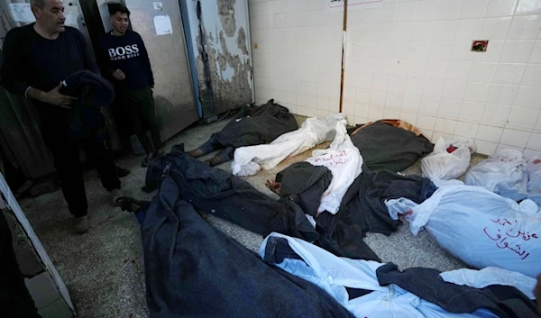 Palestinians look at the bodies of relatives killed in the Israeli bombardment of the Gaza Strip, inside a morgue of Al Aqsa hospital, in Deir al Balah, Gaza Strip, Tuesday, Feb. 6, 2024. (AP Photo)