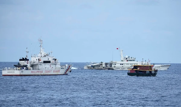 A Philippine coast guard and a supply boat maneuver as a Chinese coast guard ship tries to block its way near Second Thomas Shoal, at the disputed South China Sea on Tuesday, Aug. 22, 2023 (AP)