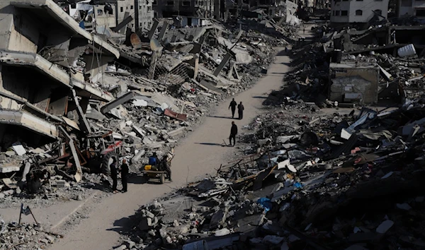 Palestinians walk through the destruction from the Israeli offensive in Jabaliya refugee camp in the Gaza Strip on Thursday, Feb. 29, 2024. (AP)