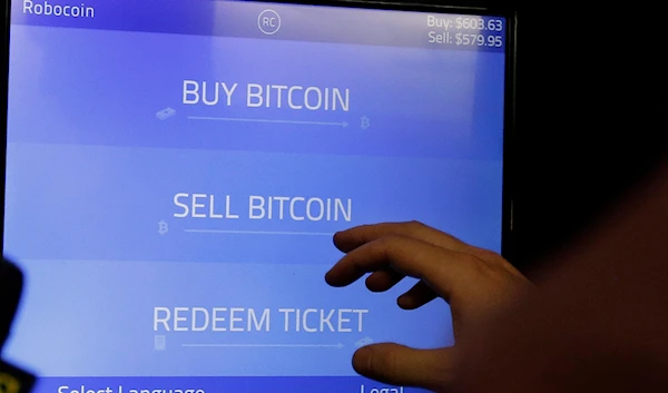 In this Thursday, March 20, 2014, file photo, Christopher David uses a Robocoin kiosk to sell bitcoins outside of the 500 Startups' Bitcoinference in Mountain View, Calif.(AP)