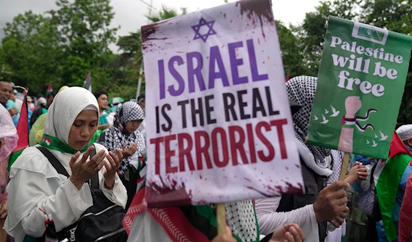 Protesters display posters as they pray during a rally in support of the Palestinians in Gaza, outside the US Embassy in Jakarta, Indonesia, Saturday, March 9, 2024.(AP)