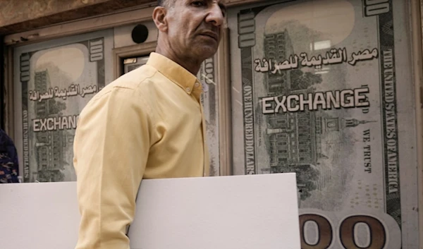 An Egyptian walks past an exchange office in Cairo, Egypt, Wednesday, March 6, 2024 (AP)