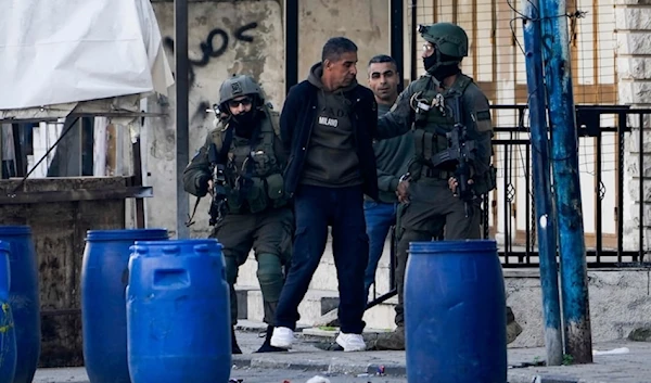 IOF arrest two Palestinian men during a military raid in the Askar refugee camp near the occupied west bank of Nablus, occupied Palestine, December 31, 2023. (AP)