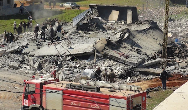 Civil defence workers and firefighters gather near a destroyed warehouse which was attacked by Israeli airstrikes, on the Hezbollah stronghold town of Safri, near Baalbek town, east Lebanon, Tuesday, March 12, 2024