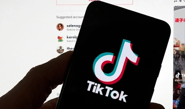 The TikTok logo is seen on a mobile in front of a computer screen which displays the TikTok home screen in 2023 in Boston. (AP)