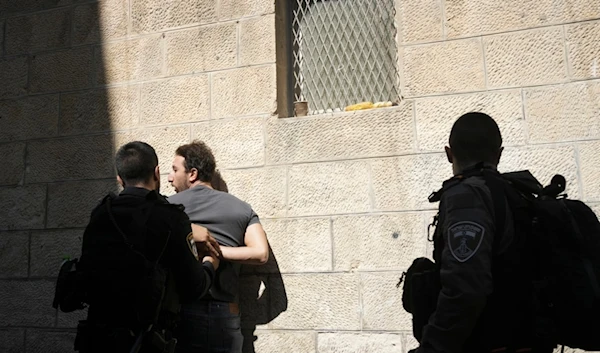 Israeli occupation forces detain a Palestinian in the Old City in al-Quds, Friday, Oct. 13, 2023. (AP)