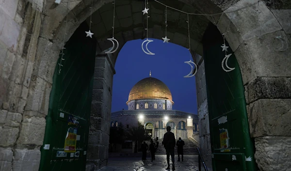 Palestinians walk next to the Dome of Rock Mosque at the Al-Aqsa Mosque compound in al-Qus's Old City, on Sunday, March 10, 2024.(AP)