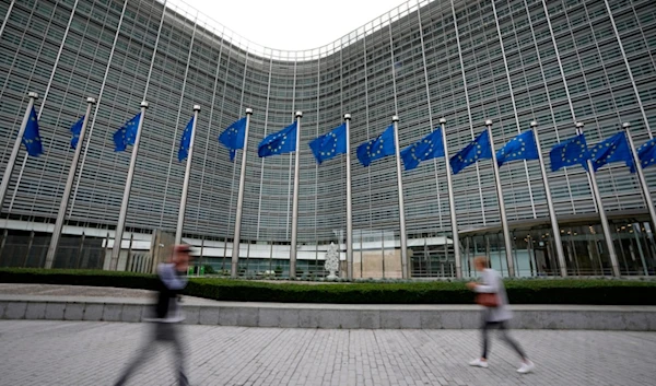 European Union flags wave in the wind as pedestrians walk by EU headquarters in Brussels, on Sept. 20, 2023. (AP)