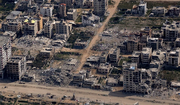 Destroyed buildings by Israeli strikes are seen through the window of an airplane from the US Air Force, as they stand in the Gaza Strip, Thursday, March 14, 2024. (AP)